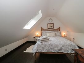 A bedroom with a bed and artwork at Ruby’s Den Ashton Keynes
