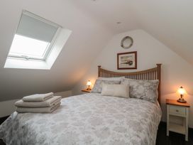 A bedroom with a bed and bedside tables at Ruby's Den in Ashton Keynes