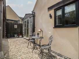 A garden with a small table and chairs beside a fence at Ruby’s Den Ashton Keynes