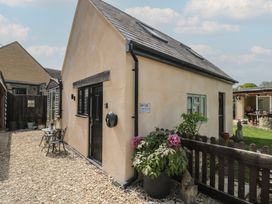 An outdoor view of a house with a garden at Ruby’s Den in Ashton Keynes