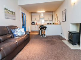 A living room with a sofa and kitchen counter at Flat 2, Dorstan in Carnforth