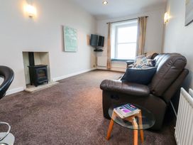 A living room with a sofa and television at Flat 2, Dorstan in Carnforth