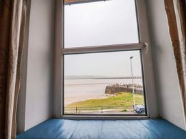 A window with a view of a pier and road at Flat 2, Dorstan in Carnforth