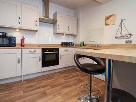 A kitchen with cabinets and appliances at Flat 2, Dorstan in Carnforth