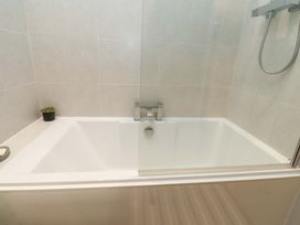 A bathroom with a bathtub and a showerhead at Flat 2, Dorstan in Carnforth