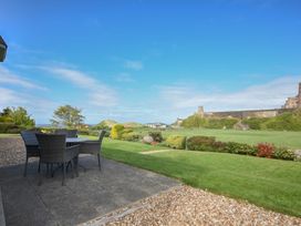 A garden with furniture facing a castle at Northrawe in Bamburgh
