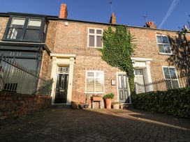 An outdoor view of a brick exterior with front doors and planters at Blacksmiths Retreat in York