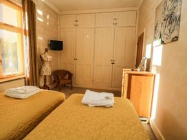 A bedroom with two beds and a wardrobe at Blacksmiths Retreat in York