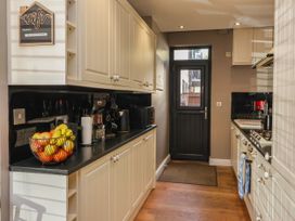 A kitchen with cabinets and a door at Blacksmith Mews in York