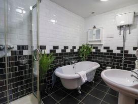 A bathroom with a bathtub, shower, and sink at Blacksmith Mews in York