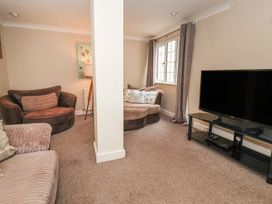 A living room with a sofa and television at Blacksmiths Mews in York