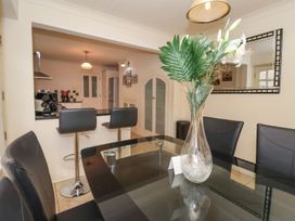 A dining room with a glass table and kitchen view at Blacksmiths Mews in York