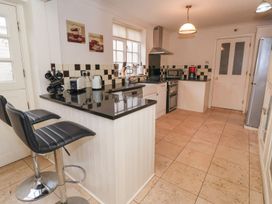A kitchen with appliances and bar stools at Blacksmiths Mews in York