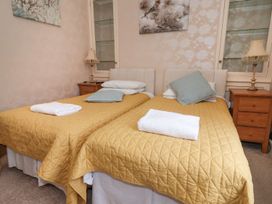 A bedroom with two beds and a bedside table at Blacksmiths Mews in York