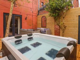 An outdoor area with a hot tub and seating at Blacksmiths Retreat, York
