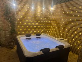 A hot tub with lights and wooden wall at Blacksmiths Retreat in York