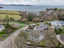 An aerial view of a coastal area with houses and beach huts at Broadsands in Paignton