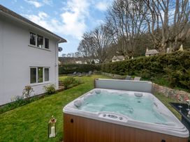 A garden with a hot tub and lounge chairs at Broadsands in Paignton