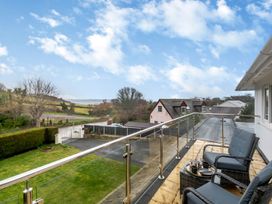 A balcony with chairs and table at Broadsands Paignton