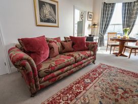 A living room with a floral sofa and dining table at Masons Place in Whitby