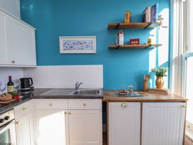 A kitchen with a sink and shelves at Masons Place in Whitby