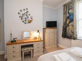 A bedroom with a dressing table and a television at Masons Place, Whitby