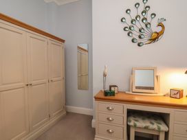 A bedroom with a wardrobe, desk, and mirror at Masons Place in Whitby