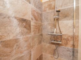 A shower with wall tiles at Masons Place in Whitby