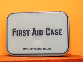 A first aid case on a surface with an orange background at Masons Place in Whitby