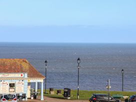 An ocean view with an ice cream shop and street lamps at Masons Place in Whitby
