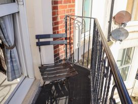 A balcony with a chair and a brick wall at Masons Place in Whitby