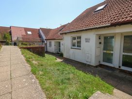 A pathway leading to buildings with grass areas at 32 Bowleaze Coveway Weymouth