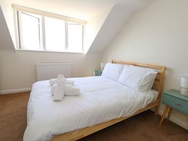 A bedroom with a bed and two windows at 32 Bowleaze Coveway in Weymouth