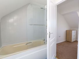 A bathroom with a bathtub and a shower at 32 Bowleaze Coveway in Weymouth