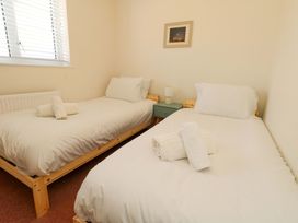 A bedroom with two single beds and towels on the beds at 32 Bowleaze Coveway Weymouth