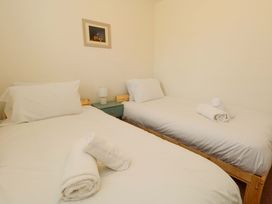 A bedroom with two beds and a bedside table at 32 Bowleaze Coveway in Weymouth