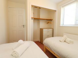 A bedroom with two beds and storage at 32 Bowleaze Coveway in Weymouth