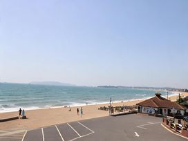 A beach view with people and a restaurant at 32 Bowleaze Coveway Weymouth