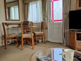A living room with a mirror and furniture at Reighton Sands Holiday Park - Holiday Accommodation 17652, Filey
