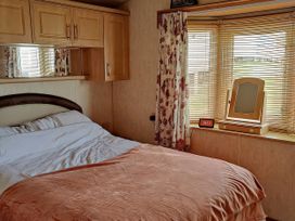 A bedroom with a bed and window at Reighton Sands Holiday Park - Holiday Accommodation 17652 in Filey