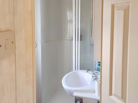 A bathroom with a shower and sink at Reighton Sands Holiday Park - Holiday Accommodation 17652 in Filey