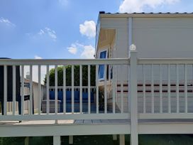 An outdoor area with a deck and seating at Reighton Sands Holiday Park - Holiday Accommodation 17652, Filey