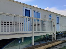 A mobile home with a deck and steps at Reighton Sands Holiday Park - Holiday Accommodation 17652, Filey