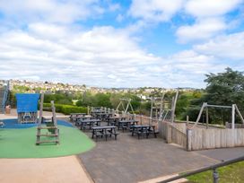 An outdoor playground with swings and climbing frame at Static Caravan Hoburne Devon Bay in Paignton