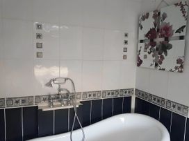 A bathroom with a bathtub and wall art at House - Sleeps 7 - Garden - Pets Ok - Parking in Torquay