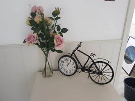 A decorative arrangement with roses, a clock, and a bicycle at House - Sleeps 7 - Garden - Pets Ok - Parking Torquay