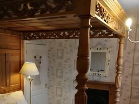 A bedroom with a wooden bed frame and lamp at House - Sleeps 7 - Garden - Pets Ok - Parking Torquay