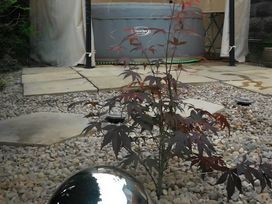 A garden with a hot tub and a small plant at House - Sleeps 7 - Garden - Pets Ok - Parking in Torquay