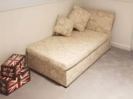 A sofa with cushions and storage boxes at House - Sleeps 7 - Garden - Pets Ok - Parking in Torquay