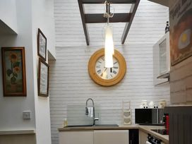 A kitchen with a clock and sink at House - Sleeps 7 - Garden - Pets Ok - Parking in Torquay